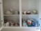 Lot of plates, cups, creamers, sugars and etc in two-door cabinet