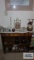 Lot of decorative items on bookcase including candle holders, figurines, trinket boxes, and night