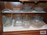 Lot of clear glass items in...bottom of cabinet including bowls, plates, basket