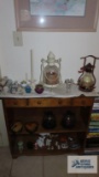 Lot of decorative items on bookcase including candle holders, figurines, trinket boxes, and night
