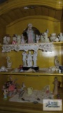 Lot of figurines, miniature clock, decorative items, vases and etc on top shelves of cabinet