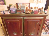 Lot of figurines, wooden houses, brass decorative lamp, mugs and etc on top of cabinet