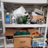 Bottles, oil lamp parts, gardening hose, books, VHS tapes and etc on shelving