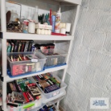 Lot of VHS tapes, candles and etc on shelving
