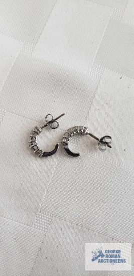 Silver colored clear gemstone half hoop earrings, marked 925, one is missing a stone