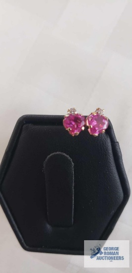 Pink and clear gemstone earrings on gold colored setting marked 10k, .6 g
