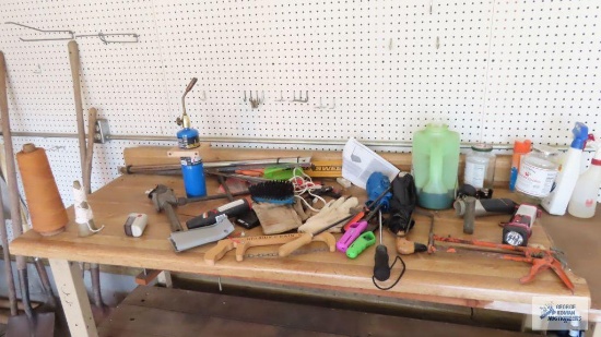 Workbench with miscellaneous items including flashlights, umbrellas, string, gloves