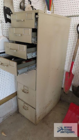 File cabinet with miscellaneous items including wood pegs, phone system batteries
