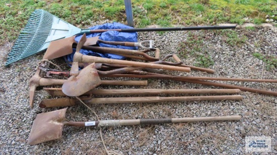 post hole digger, shovels, pick axe and other garden tools with tarp