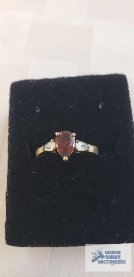 Gold colored ring with red and clear gemstones, marked 925