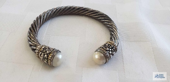 Silver colored cuff bracelet with pearl like ends, no markings found