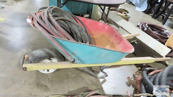 Wheelbarrow with pneumatic tire and soaker hose. Tire is flat
