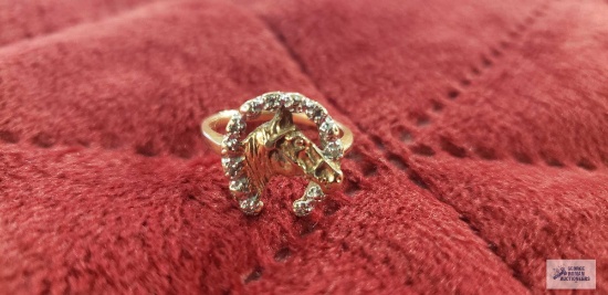 Gold colored horse with horseshoe around it ring, horseshoe has clear gemstone chips, marked 10K