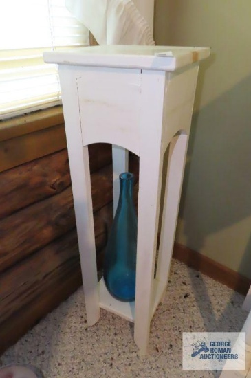 Wooden plant stand with blue glass vase