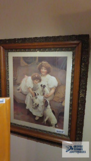 Ornately framed picture of two girls with dogs
