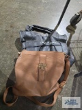 Brown and gray ladies purses. The brown one is Tory Burch