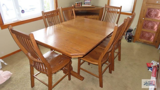 Heavy wood dining room table with three leaves and six chairs