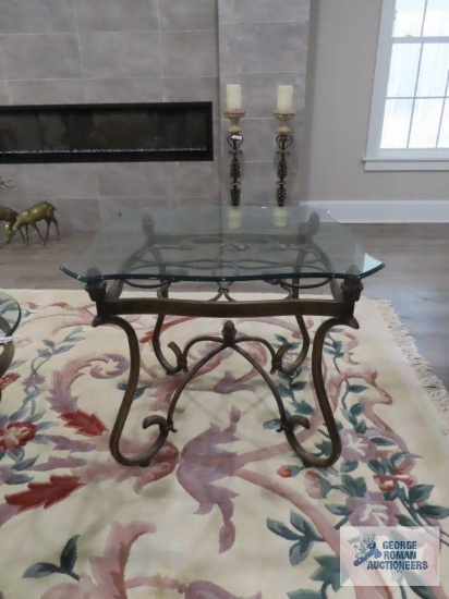 Modern glass top end table with ornate metal base. 28" square by 2' tall