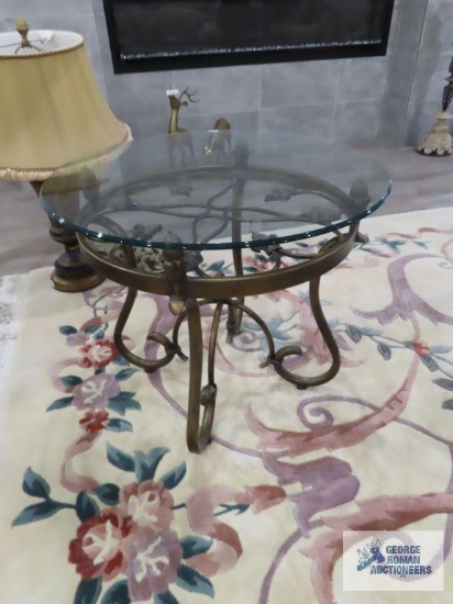 Glass top end table with ornate metal base. 28" square by 2' tall