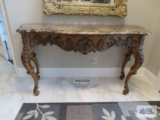 Ornate hall table with marble top and carved legs. 6' long by 40" tall by 26" deep.