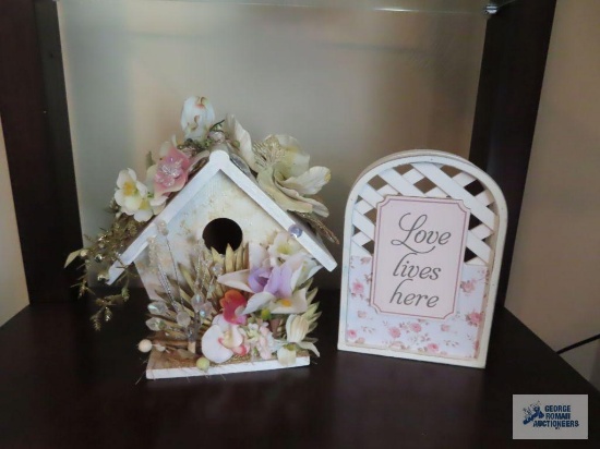 Decorative birdhouse and love lives here sign