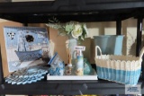 Assortment of bathroom decorations, including vase, wastebasket, wall hangings