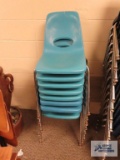 Eight light blue school chairs
