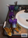 Purple bathroom set, including floral shower curtain, purple throw rug, wastebasket, soap dispenser,