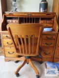 Oak roll top knee-hole desk with roll about chair made by Winners Only. On first floor.