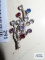 Silver colored pin with colorful gemstones, marked Van Dell Sterling.