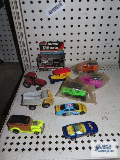 Variety of diecast and plastic cars including tractor, rock truck, NASCAR