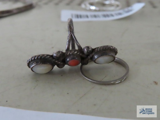 Silver colored ring with white and orange stones, no markings found. Silver colored band ring, has