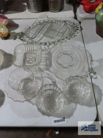 Large assortment of clear glassware including trays, celery dish, and bowls