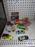 Variety of diecast and plastic cars including tractor, rock truck, NASCAR