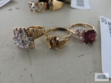 Gold colored ring with purple stone and small clear gemstones, marked 18K. GE. Gold colored ring
