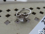 Silver colored Cupid ring with clear gemstone, marked STER.