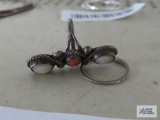 Silver colored ring with white and orange stones, no markings found. Silver colored band ring, has