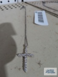 Silver colored cross pendant with clear gemstones on silver colored chain, both marked 925.