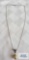 Pendant with golden pearl and dark gemstones on silver color chain, approximately 5.3 G. Both marked