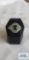 Silver colored ring with large green stone surrounded by clear gemstones, marked LNT 925 IN,