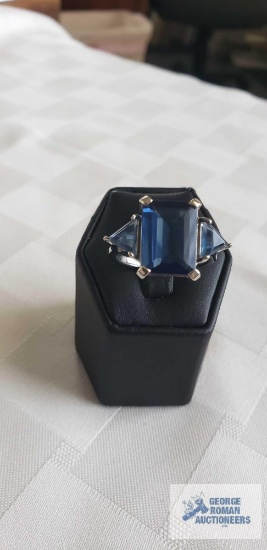 Silver colored ring with large blue stone and two smaller blue stones, marked LNT 925 IN,