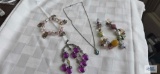 Turquoise colored stone pendant on silver colored chain, no markings,. Sarah Covington purple bead