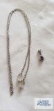 Silver colored pendant with purple stone, marked 925 and open-ended silver colored chain with clear