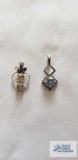 Silver colored pendant with pale blue stone, marked 925 and silver colored pendant with two yellow