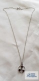 Silver colored pendant with red (garnet) colored stones on silver colored chain, both marked 925,