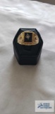 Gold colored ring with black stone and clear stone, marked 18KT HGE