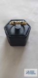 Gold colored ring with green stones, marked 18K HGE