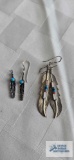 Silver colored feather earrings with stones, one marked Barney Sterling. The other one marked