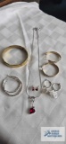 Heart-shaped pendant necklace with matching earrings. Bangle bracelet and other earrings.