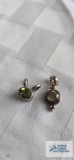 Silver colored pendant with yellow stone and silver colored pendant with greenstone. Both marked